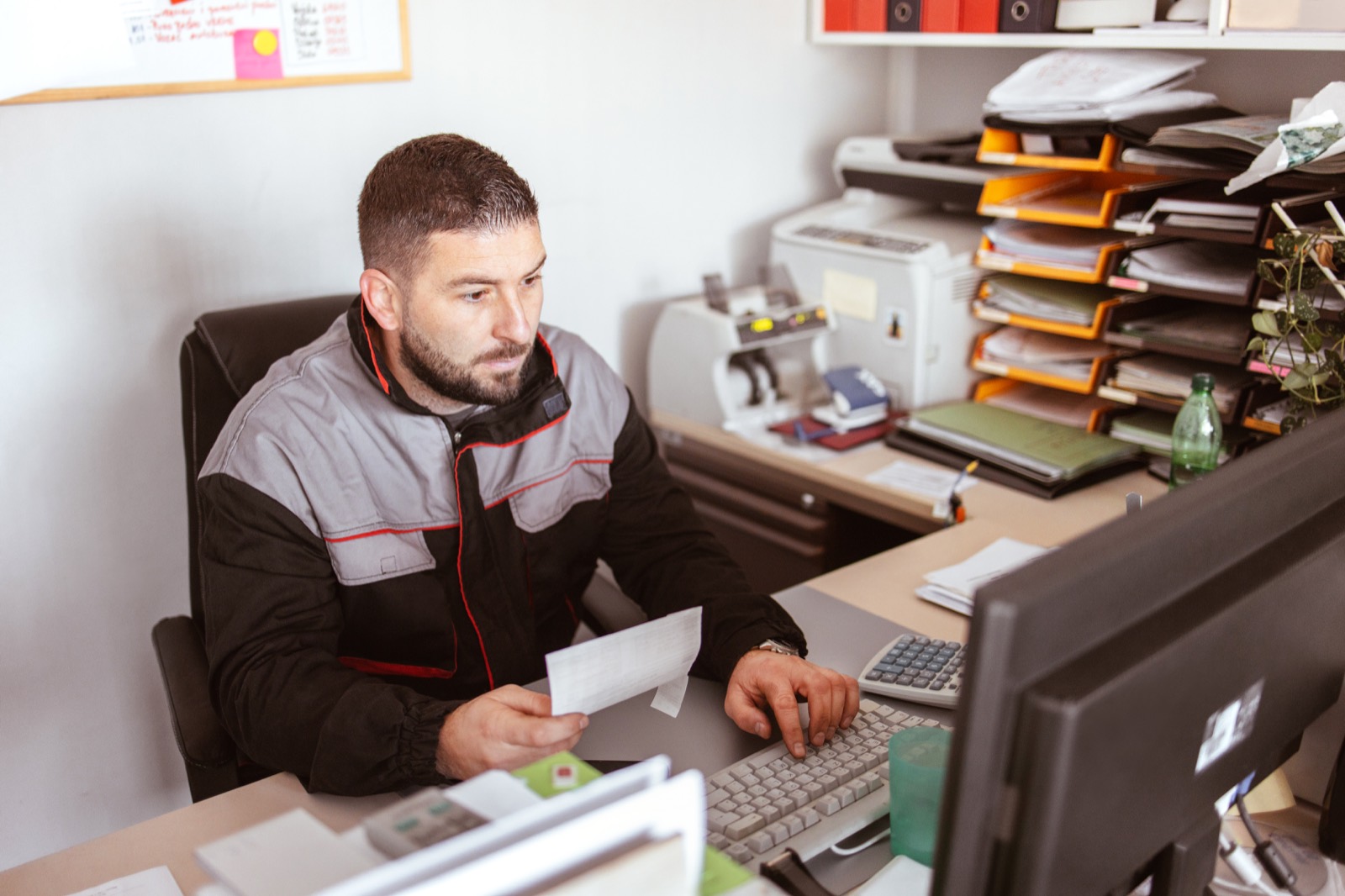 A trades operator going over paperwork at his desk.