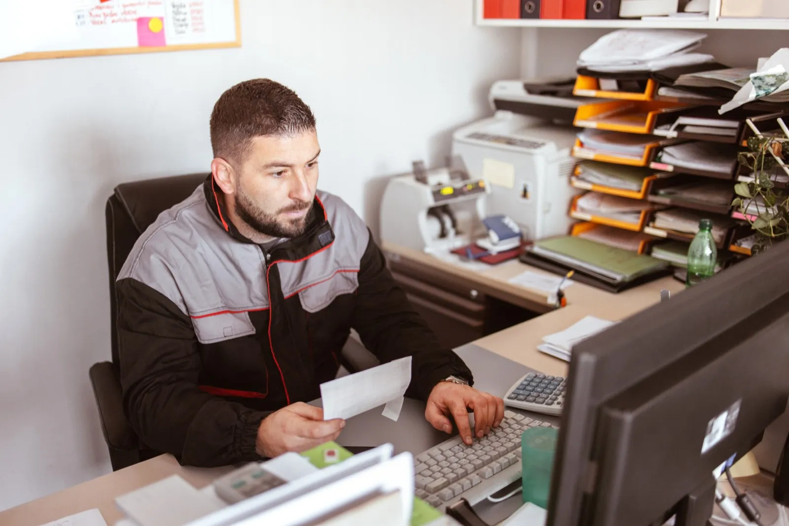 A trades operator going over paperwork at his desk.
